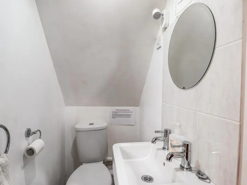 a bathroom with a white toilet and a mirror at Blairgorm Croft in Nethy Bridge