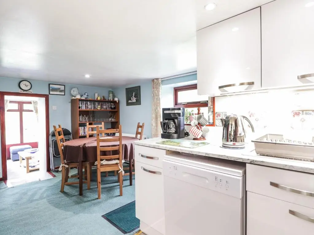 a kitchen with a table and a dining room at Blairgorm Croft in Nethy Bridge