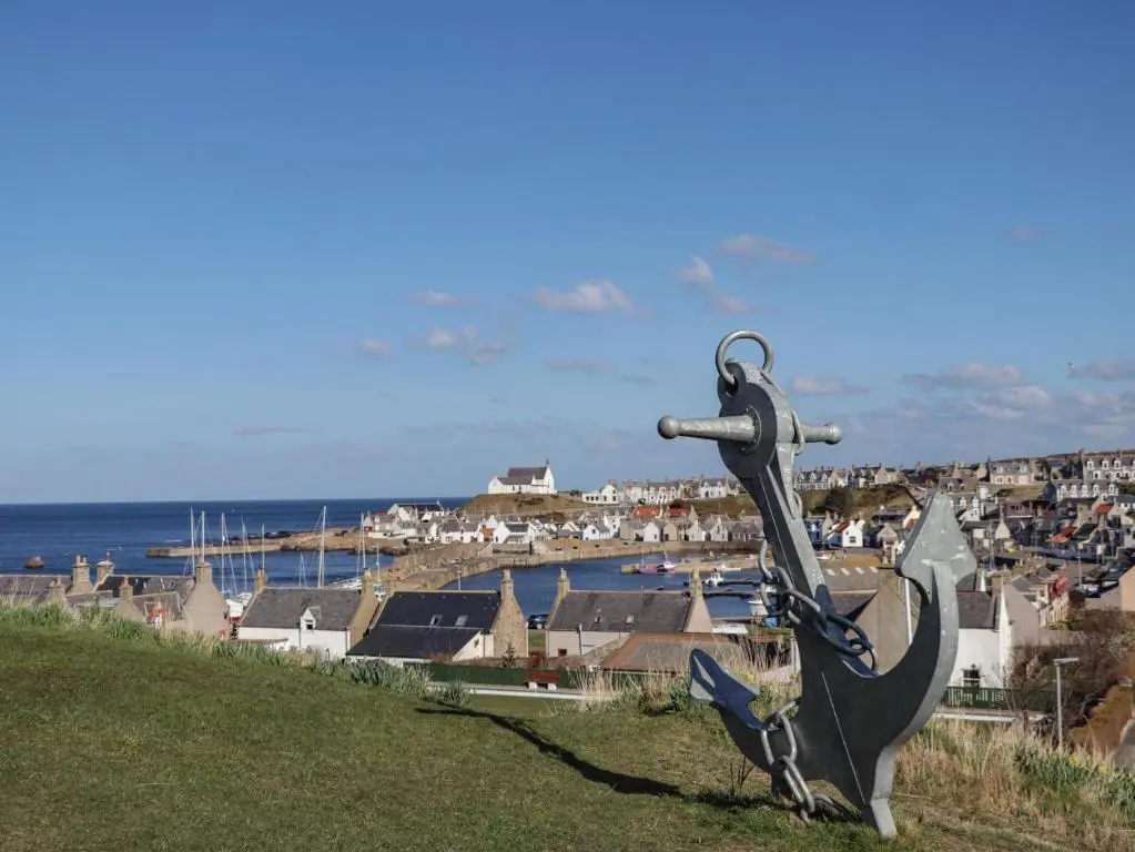a statue of a fish on a hill with a harbor at Holly Hoose in Findochty