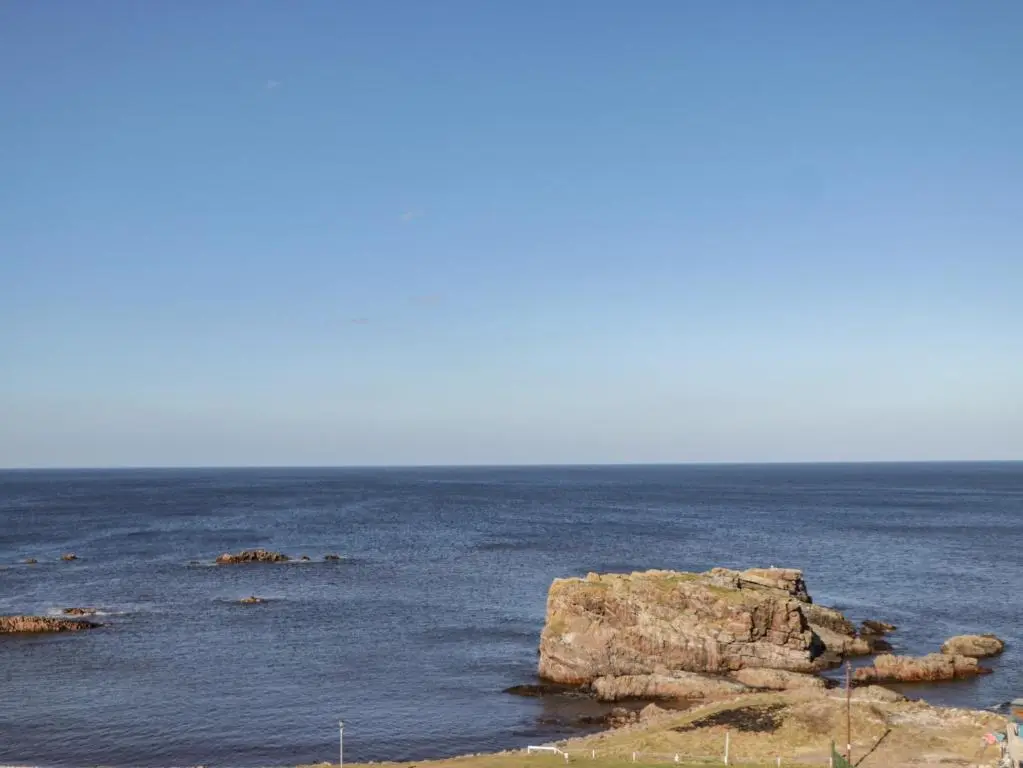 a large body of water with rocks in it at Holly Hoose in Findochty
