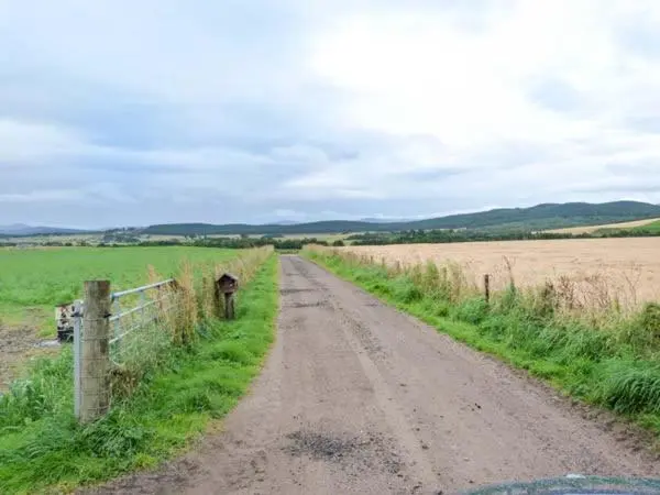 a dirt road in the middle of a field at Easter Duthil Cottage in Duthil