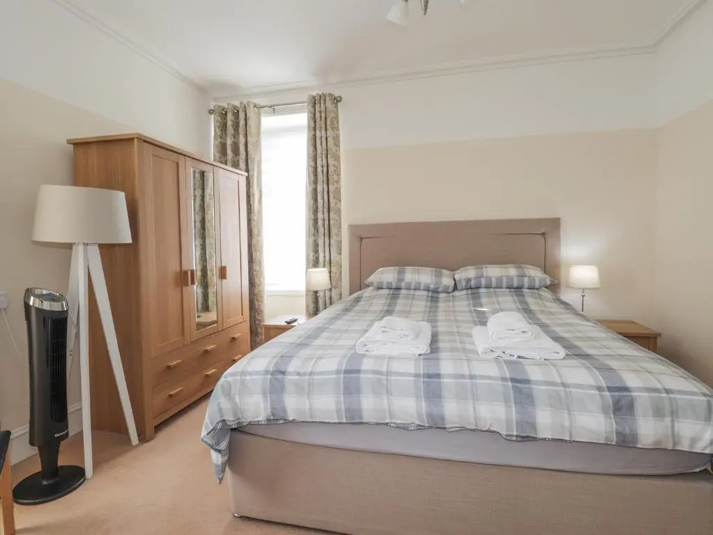 a bedroom with a bed with two towels on it at 1 Seafield Street in Cullen