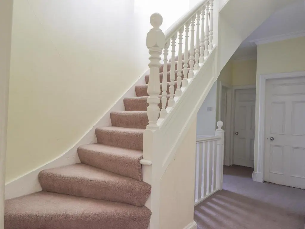 a staircase in a home with brown carpet at 1 Seafield Street in Cullen