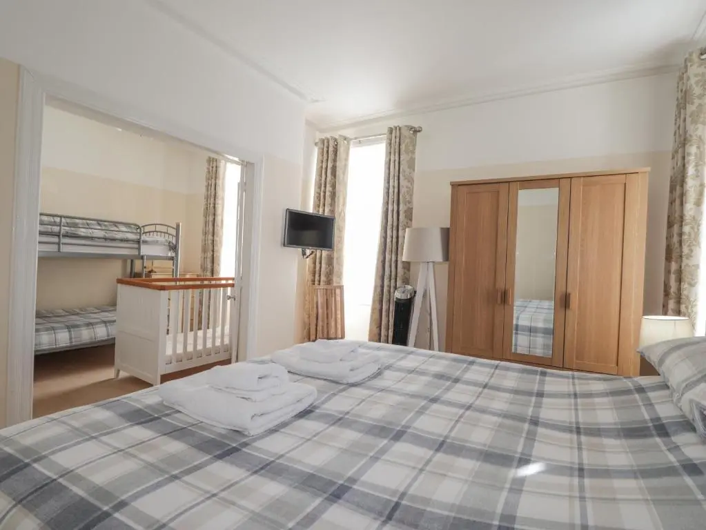 a bedroom with a bed with towels on it at 1 Seafield Street in Cullen