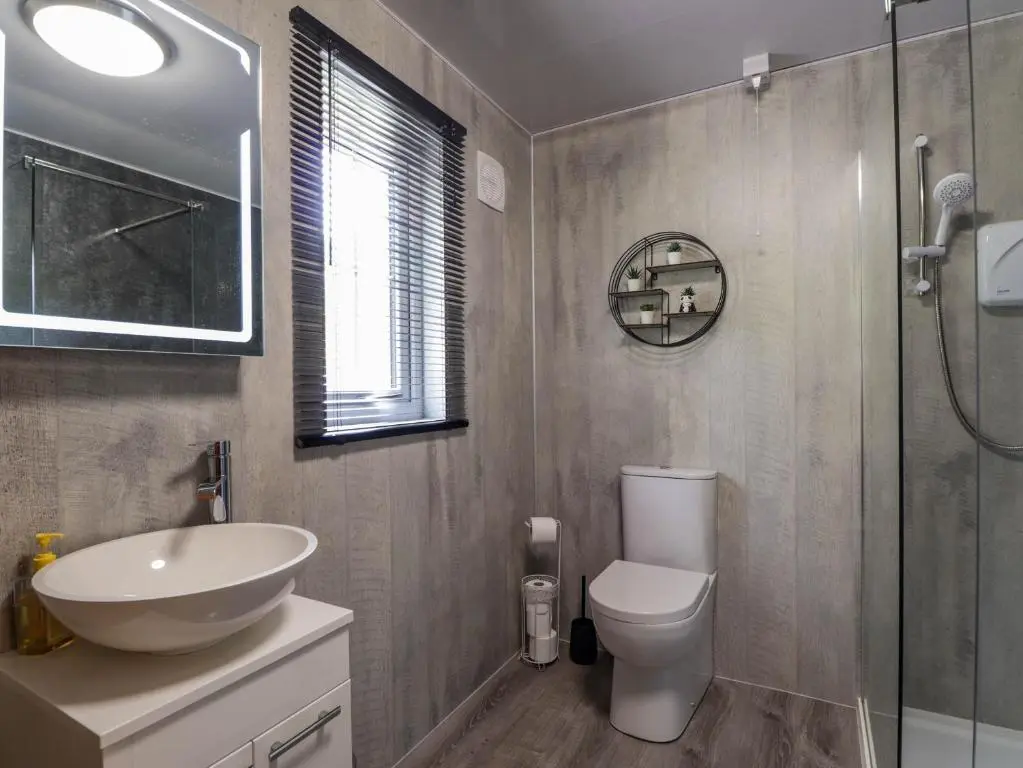 a bathroom with a sink and a toilet and a shower at Stone Water Cottage in Contin