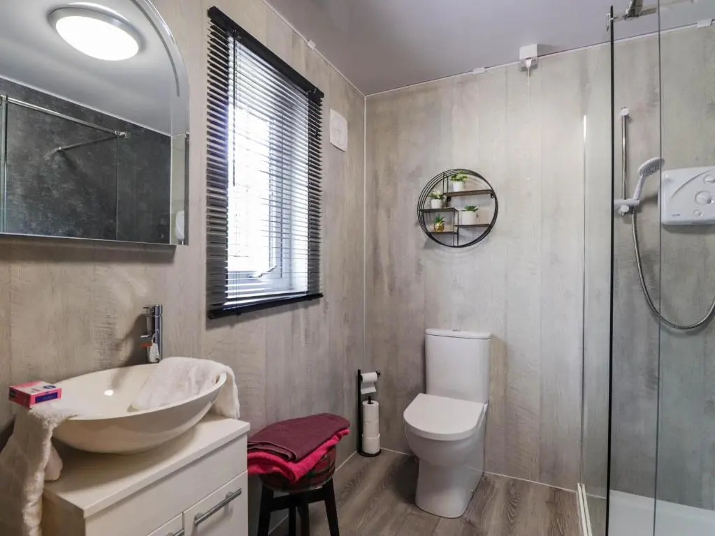 a bathroom with a toilet and a sink and a shower at Pebbles Cottage in Contin