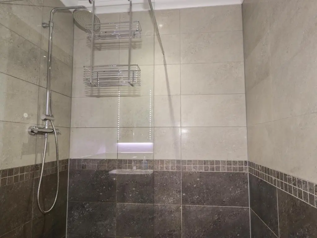a shower with a glass door in a bathroom at Little Chestnut in Muir of Ord