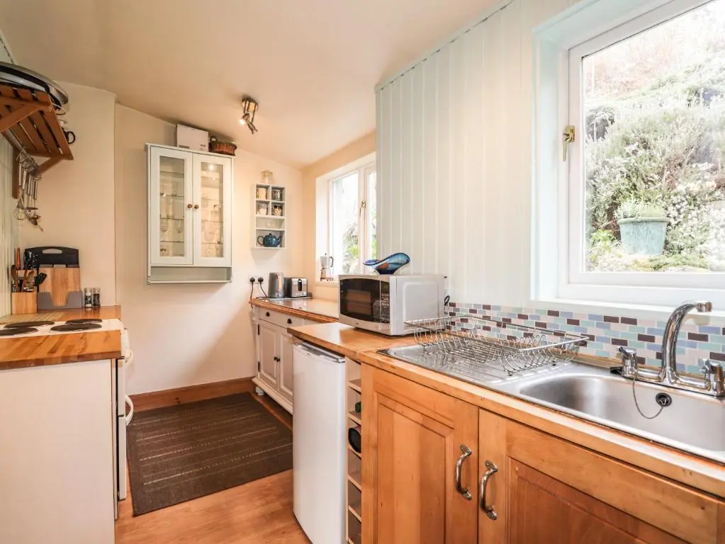 a kitchen with a sink and a microwave at Aultmore in Kingussie
