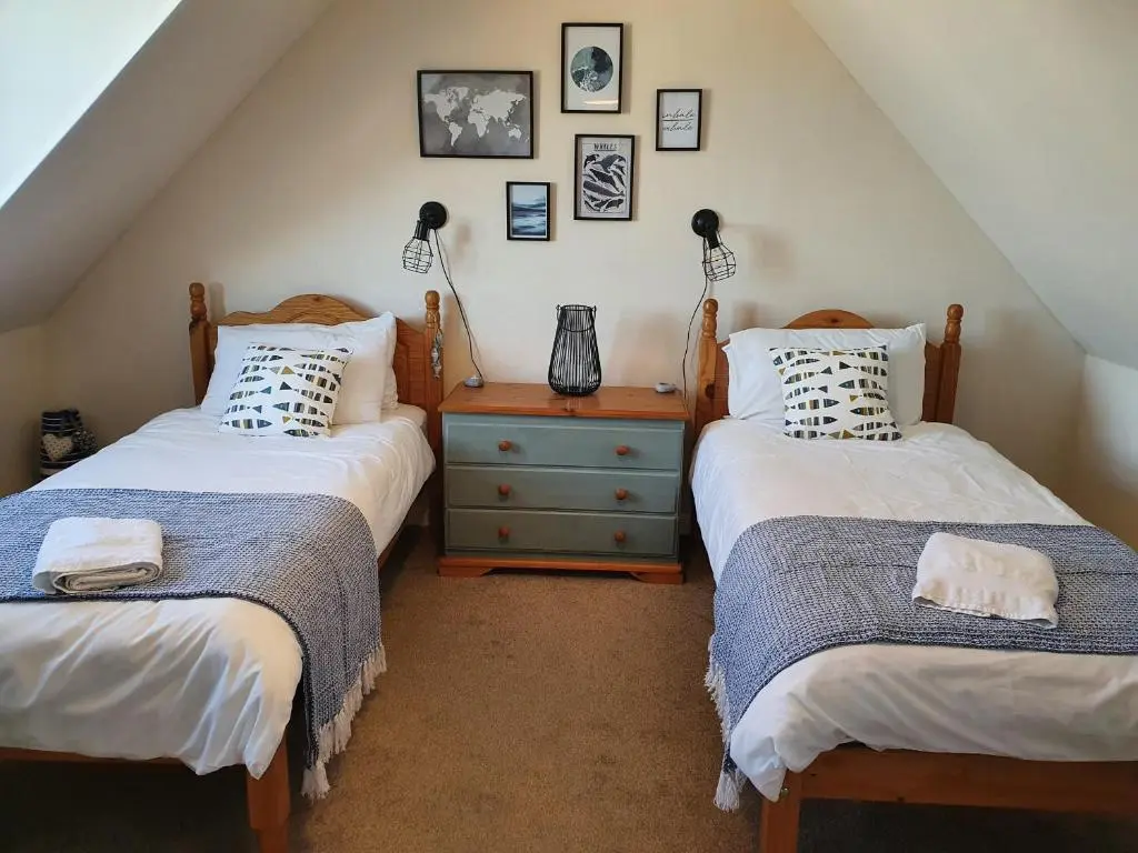 a bedroom with two beds and a dresser with lamps at Slater's in Portknockie