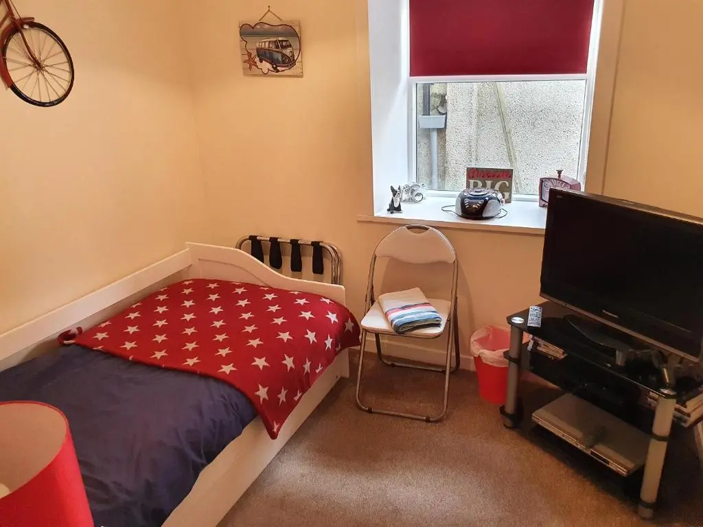a bedroom with a bed and a flat screen tv at Slater's in Portknockie