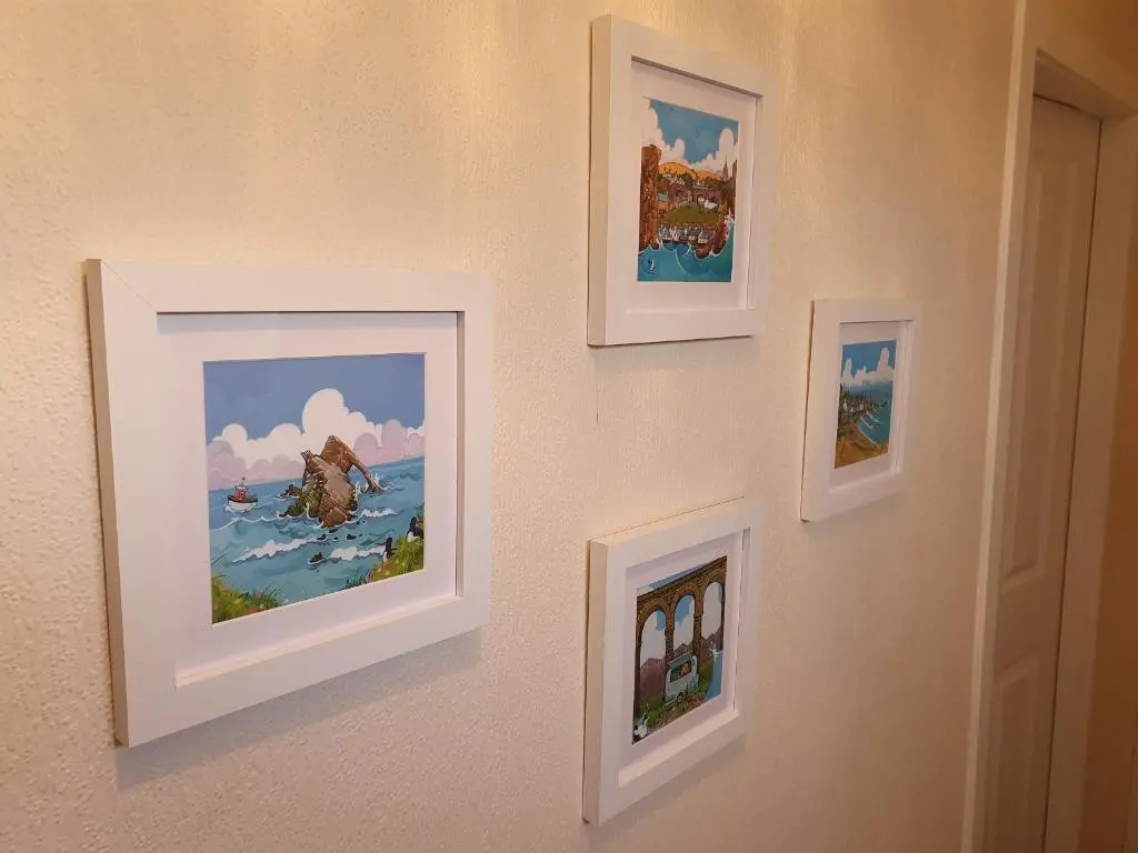 four framed paintings on a wall in a room at Slater's in Portknockie