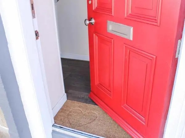 a red door in a room with a carpet at Slater's in Portknockie