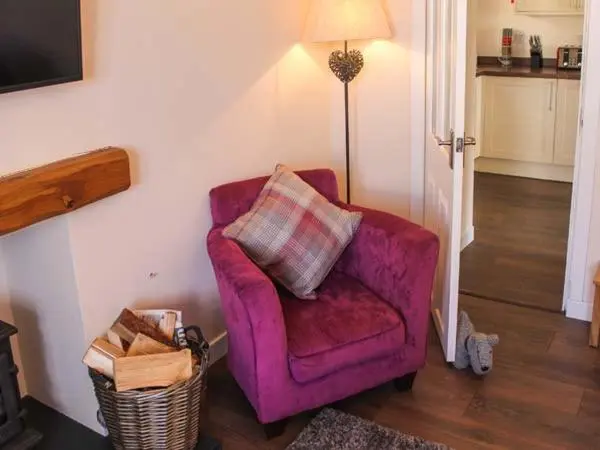 a purple chair in a living room with a lamp at Slater's in Portknockie