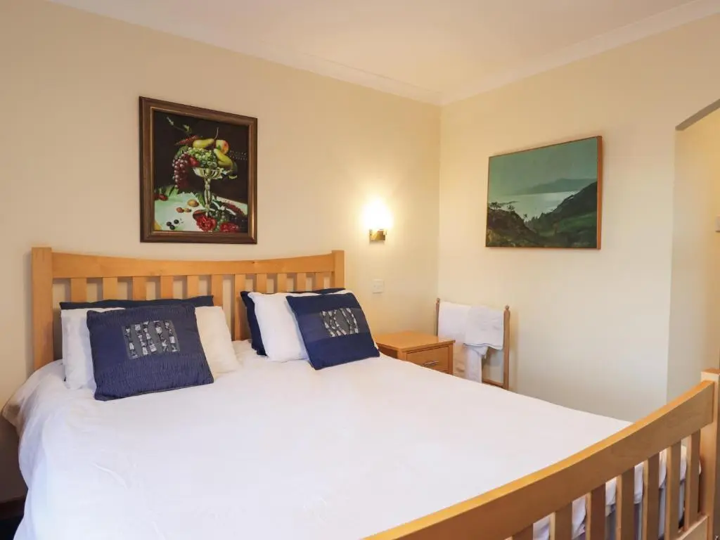 a bedroom with a large white bed with blue pillows at Bogairn in Carron