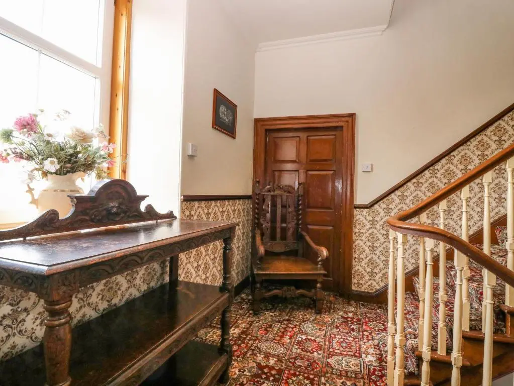 a living room with a staircase and a stair case at The West Wing in Skye of Curr