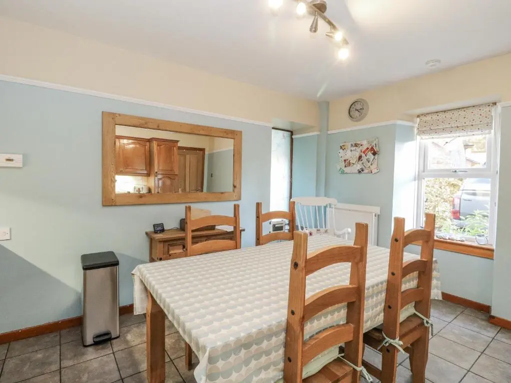 a kitchen and dining room with a table and chairs at Deskford Cottage in Balblair