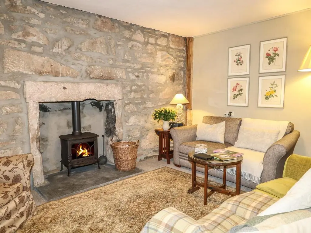 a living room with a stone wall and a fireplace at Coorie Doon in Nairn