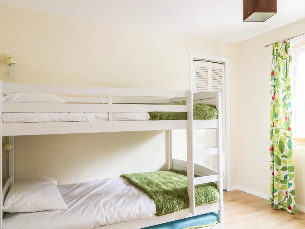 a bedroom with bunk beds with green towels at 79 Corrour Road in Aviemore