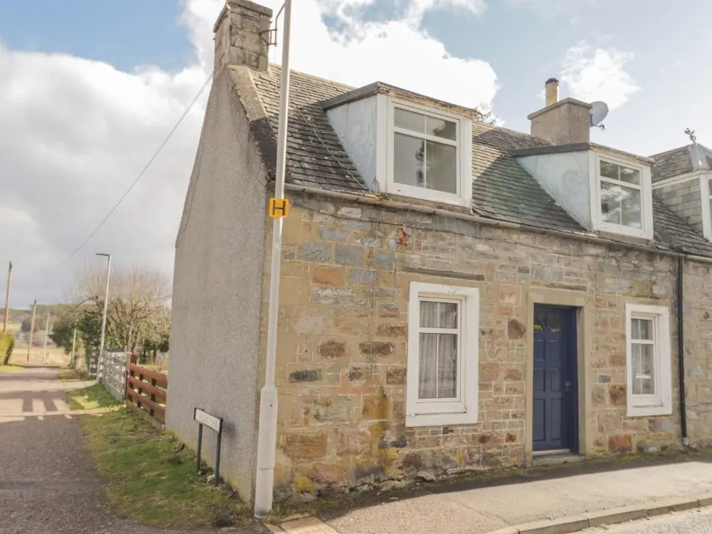 an old brick house with two windows and a blue door at Alt na Voir in Tomintoul