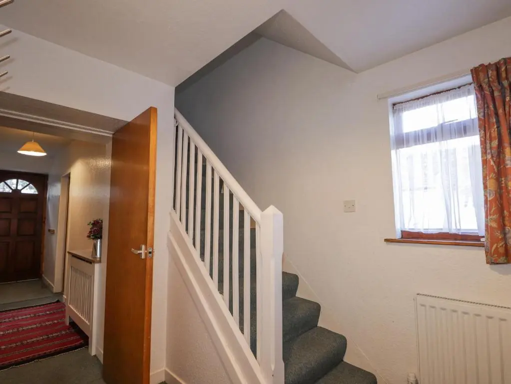 a hallway with stairs and a window and a stair case at Alt na Voir in Tomintoul