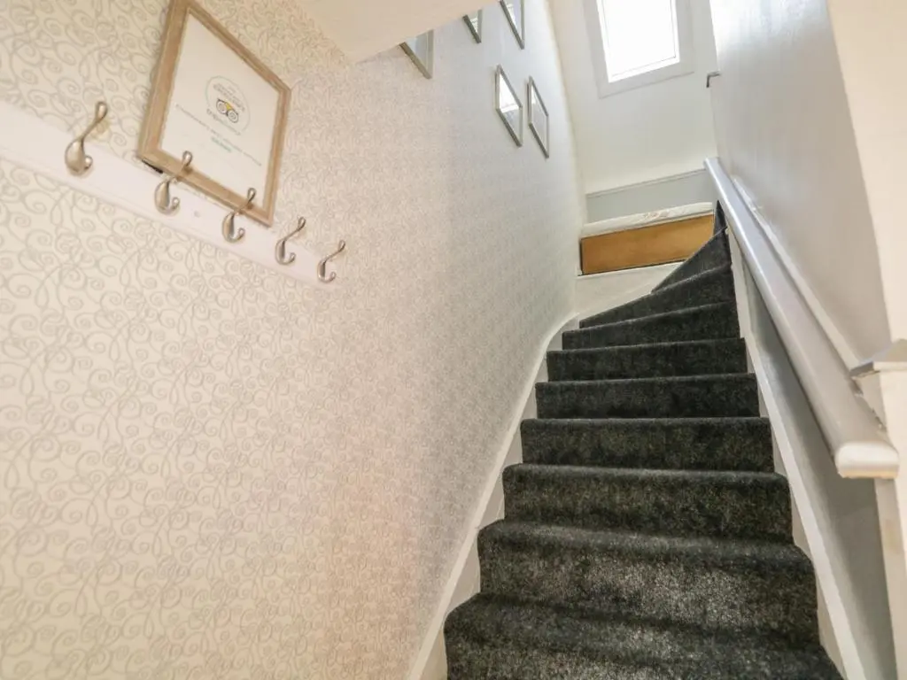 a staircase in a home with white walls and gray carpet at Fishermans Rest in Burghead