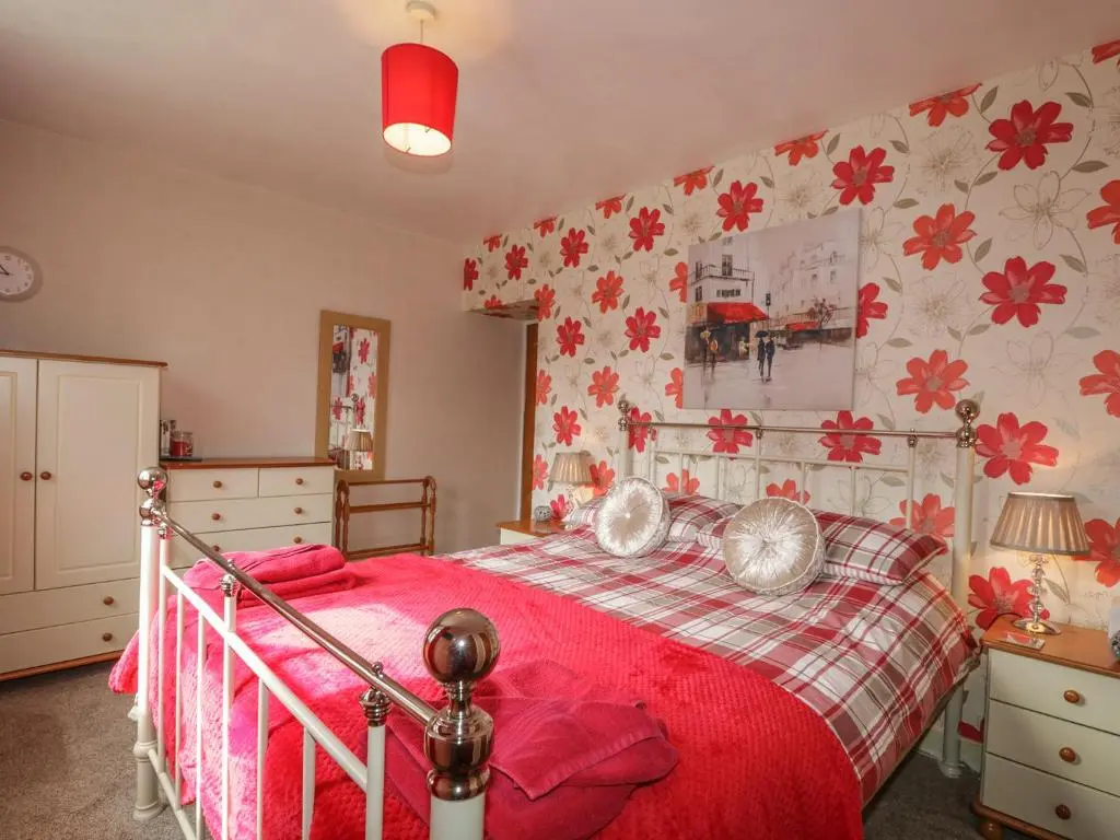 a bedroom with a bed with a red blanket at Fishermans Rest in Burghead