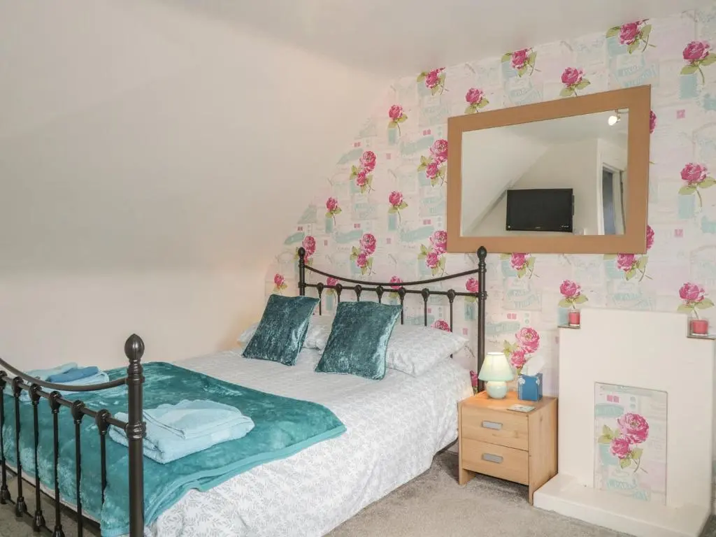 a bedroom with a bed and a mirror at Fishermans Rest in Burghead