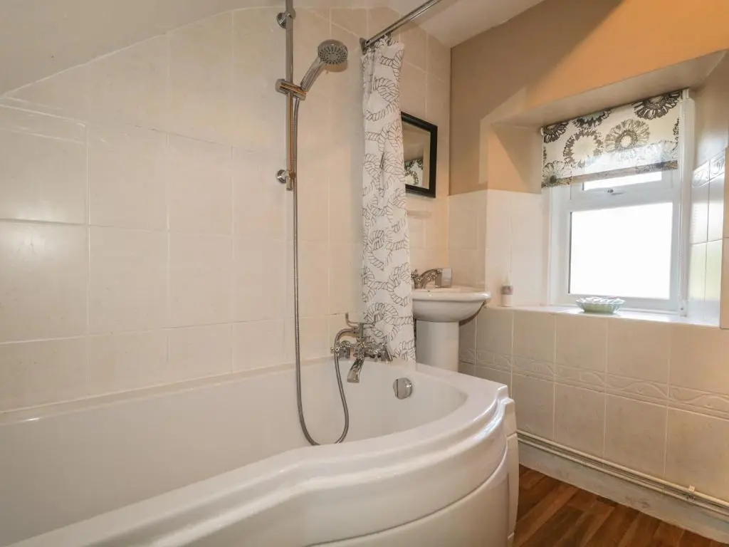 a bathroom with a shower and a tub and a sink at Fishermans Rest in Burghead