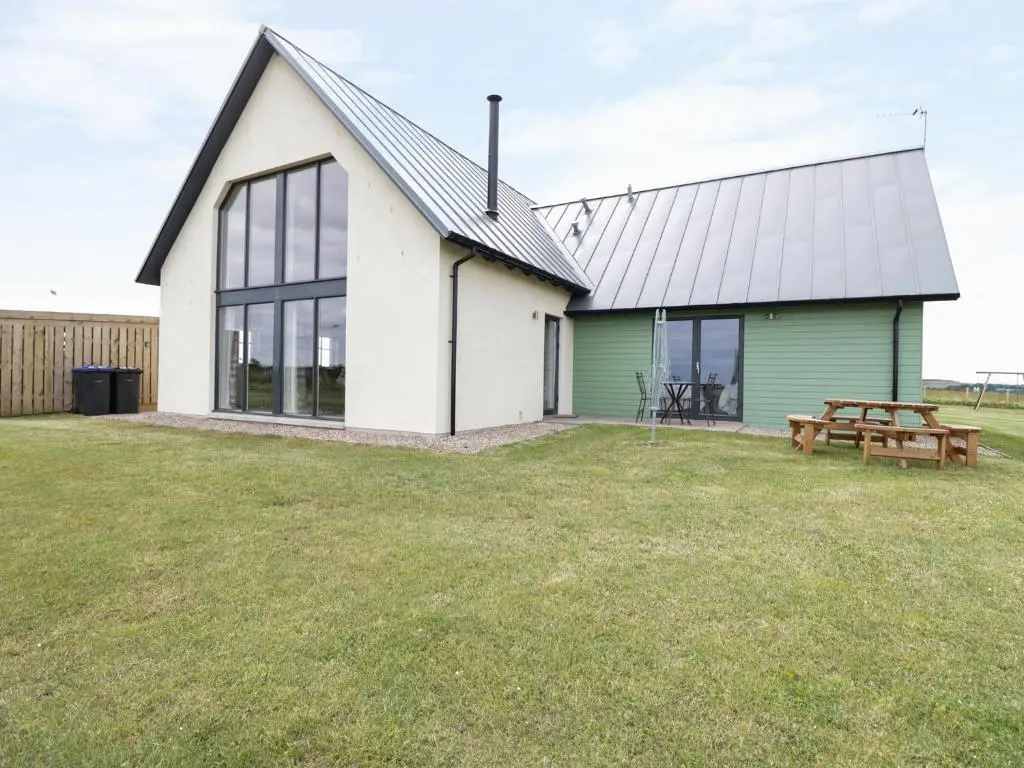 a white and green building with a picnic table at Chance Inn Lodge in Balmedie
