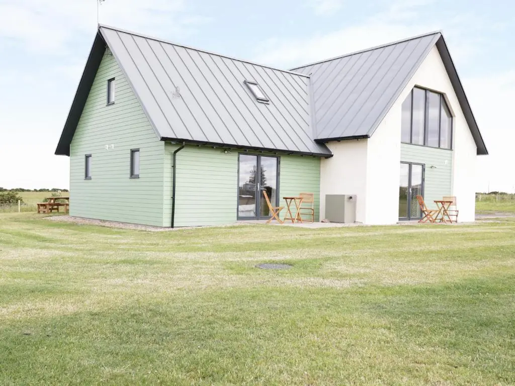 a green and white barn with a metal roof at Chance Inn Lodge in Balmedie