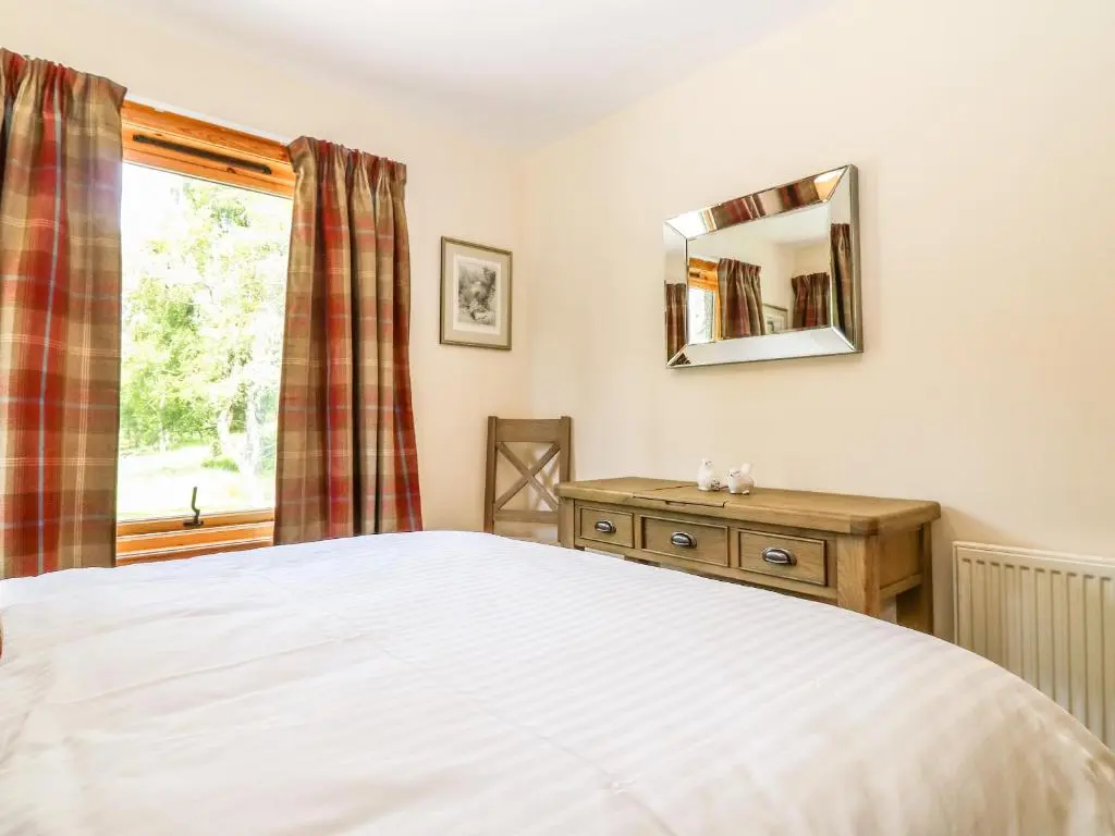 a bedroom with a bed and a window at Birchbank in Skye of Curr