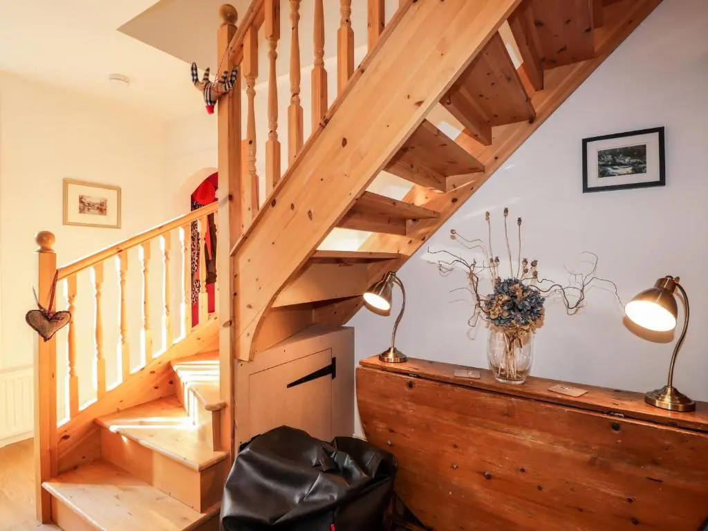 a wooden staircase in a home with two lamps at 59 Society Street in Nairn