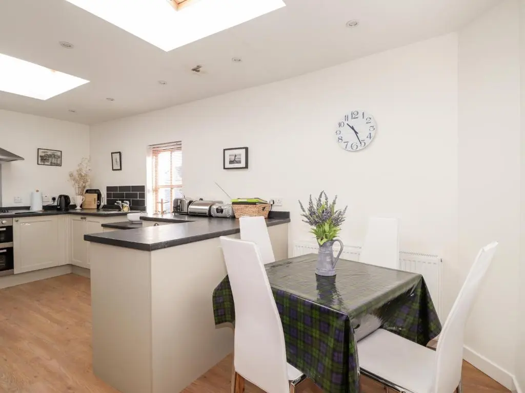 a kitchen and dining room with a table and chairs at 59 Society Street in Nairn