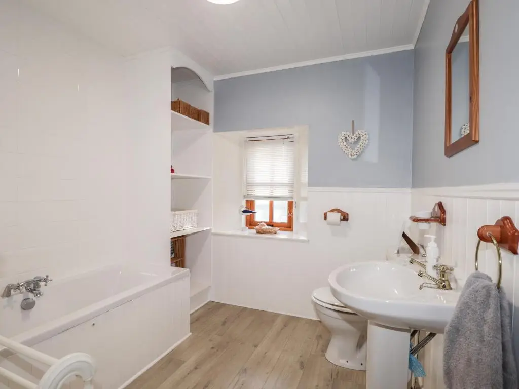 a bathroom with a tub and a sink and a toilet at 59 Society Street in Nairn