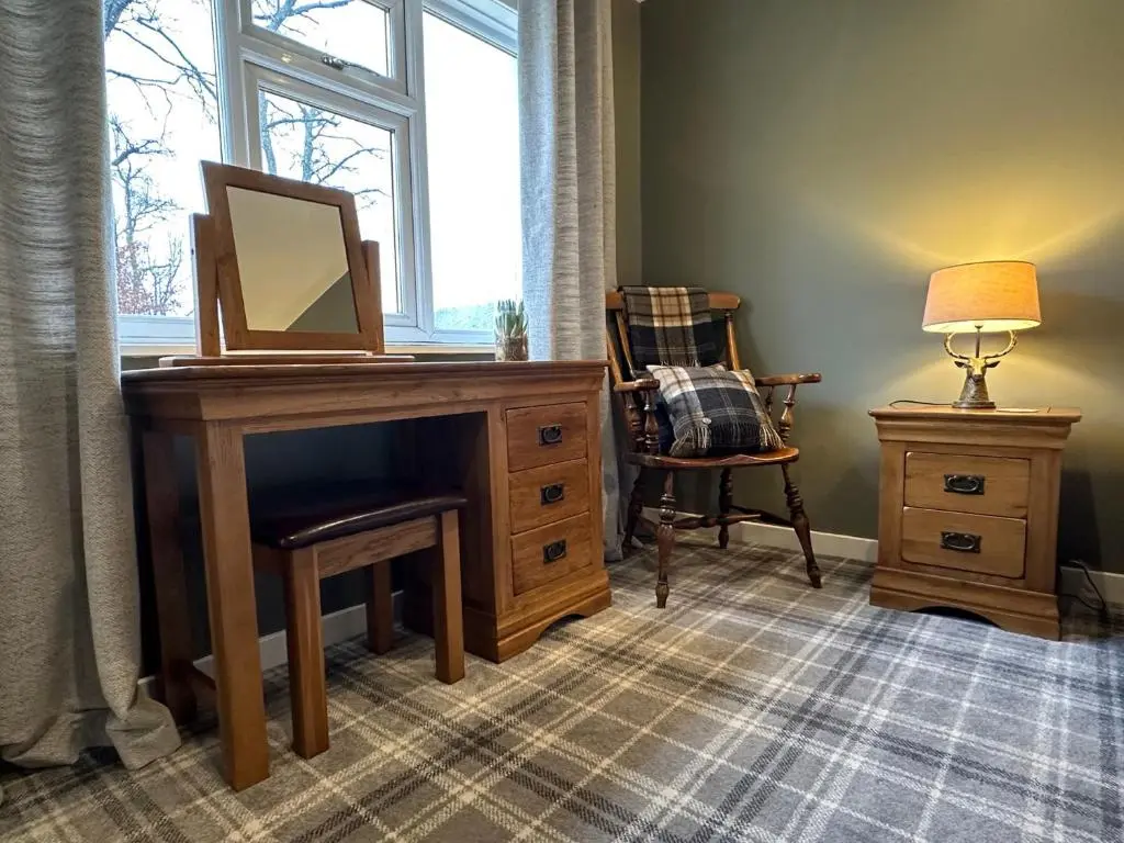 a room with a desk with a mirror and a chair at White Hillocks Cottage in Inchmill