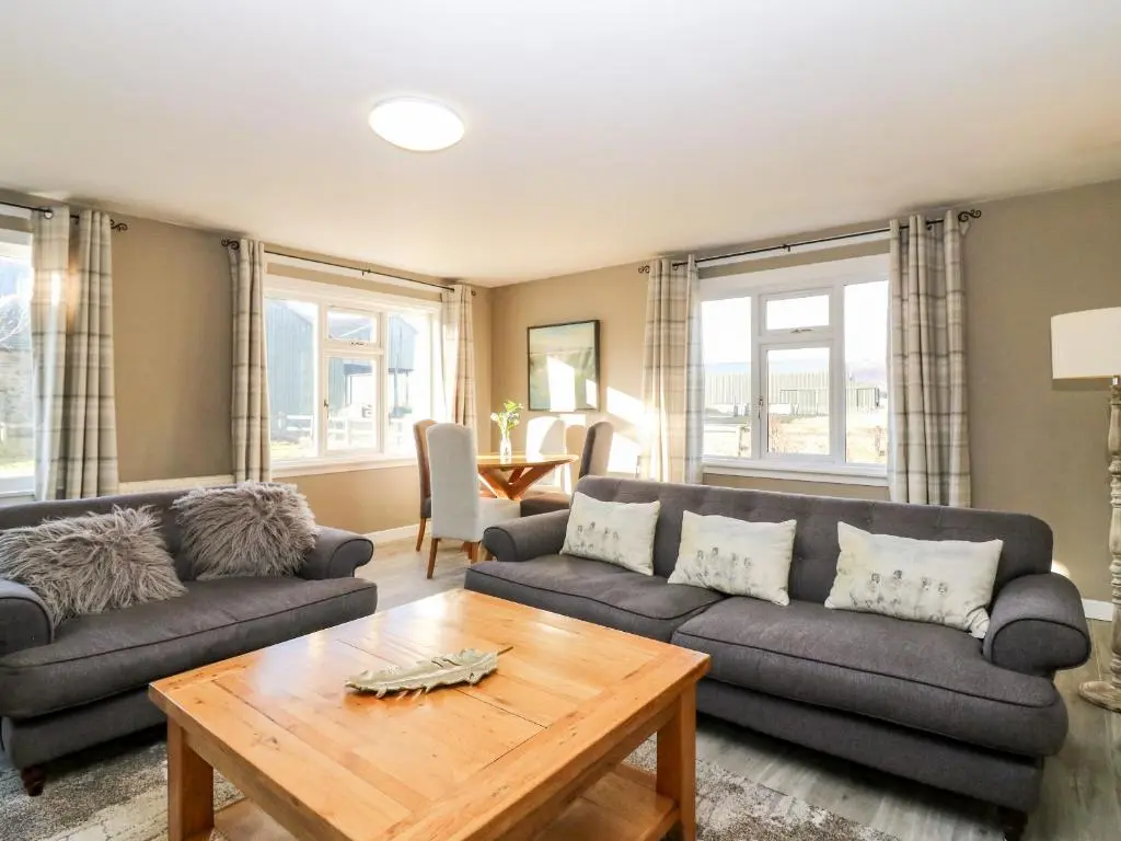 a living room with a couch and a table at White Hillocks Cottage in Inchmill