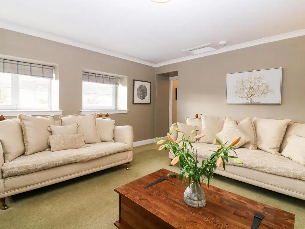 a living room with two couches and a coffee table at White Hillocks Farm House in Inchmill