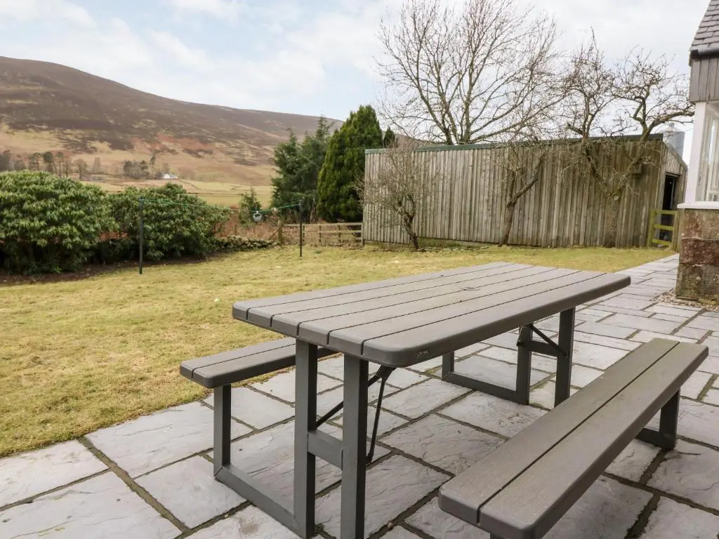 a picnic table and two benches on a patio at White Hillocks Farm House in Inchmill