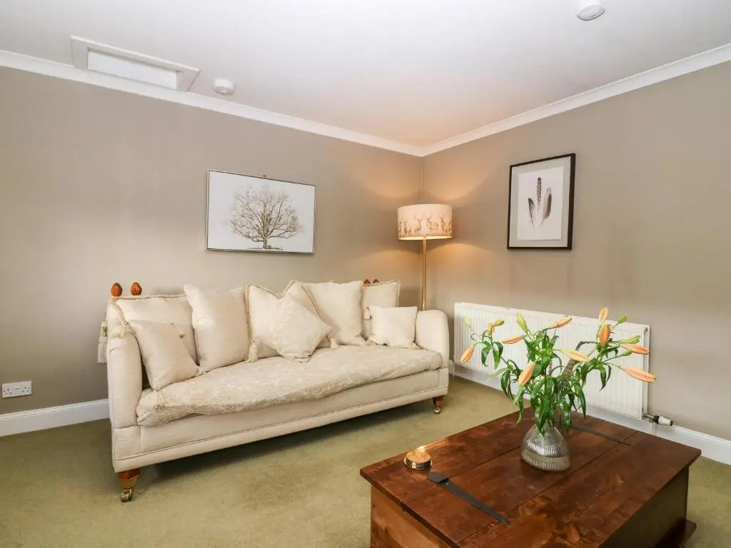 a living room with a couch and a table at White Hillocks Farm House in Inchmill