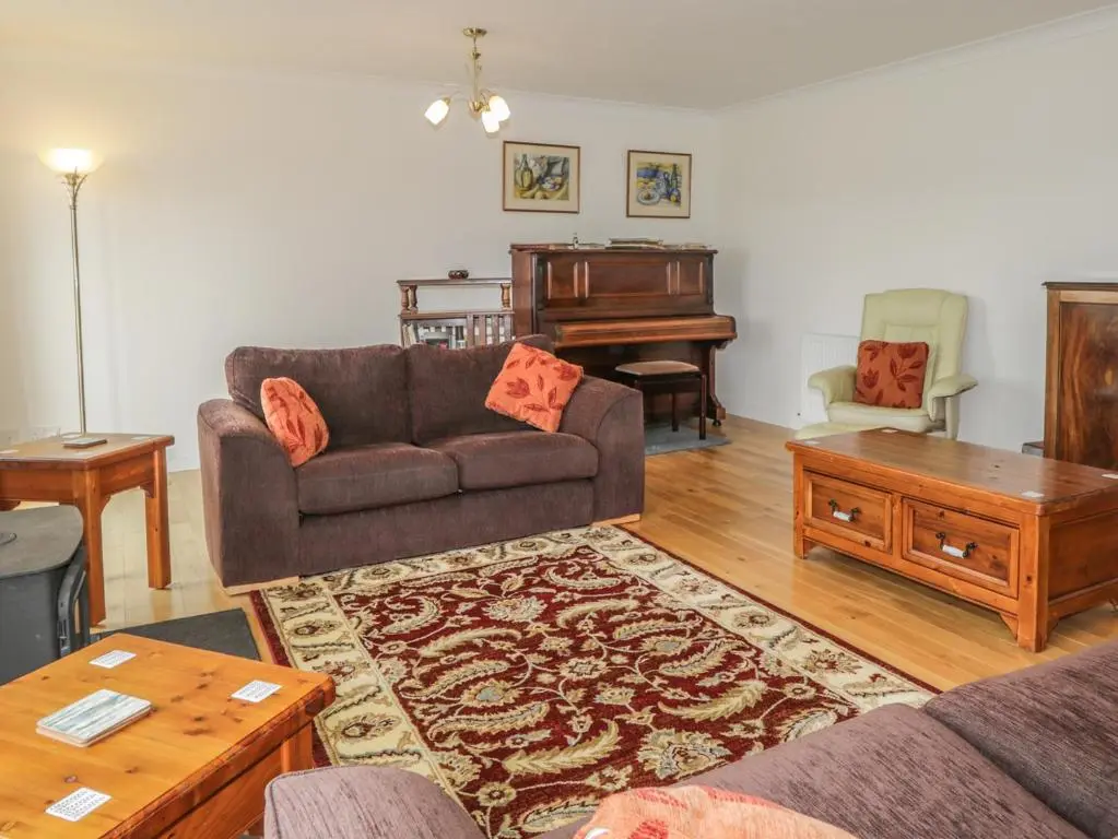 a living room with a couch and a piano at Glaven in Bonar Bridge