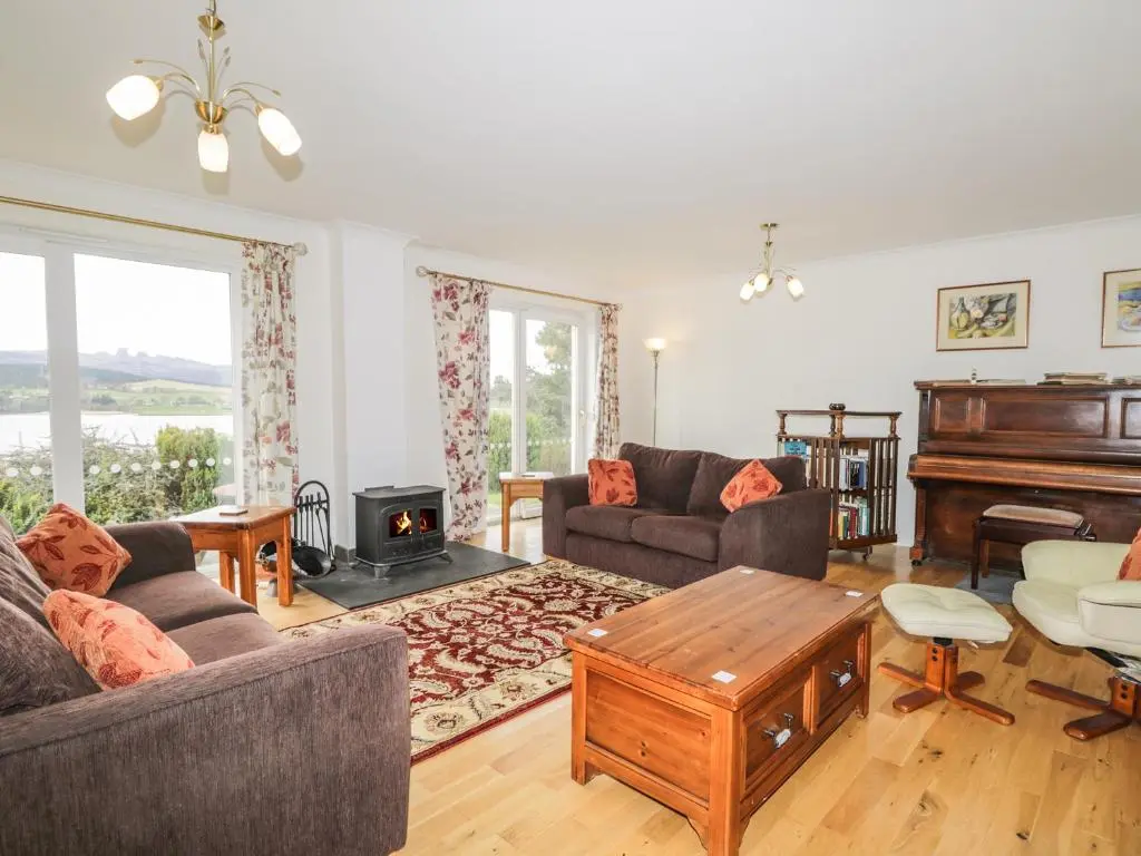 a living room with a couch and a piano at Glaven in Bonar Bridge