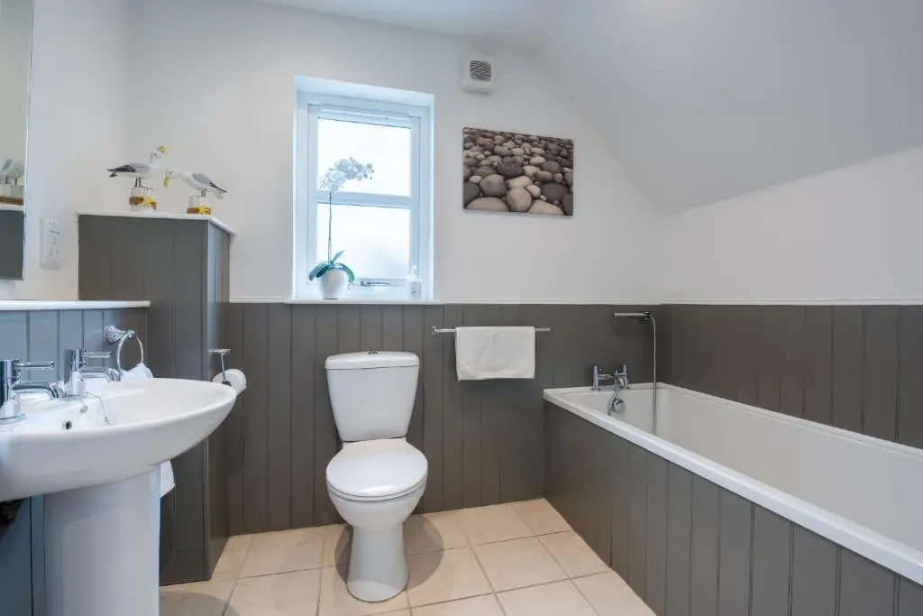 a bathroom with a toilet and a sink and a bath tub at Kerrisdale in Dornoch