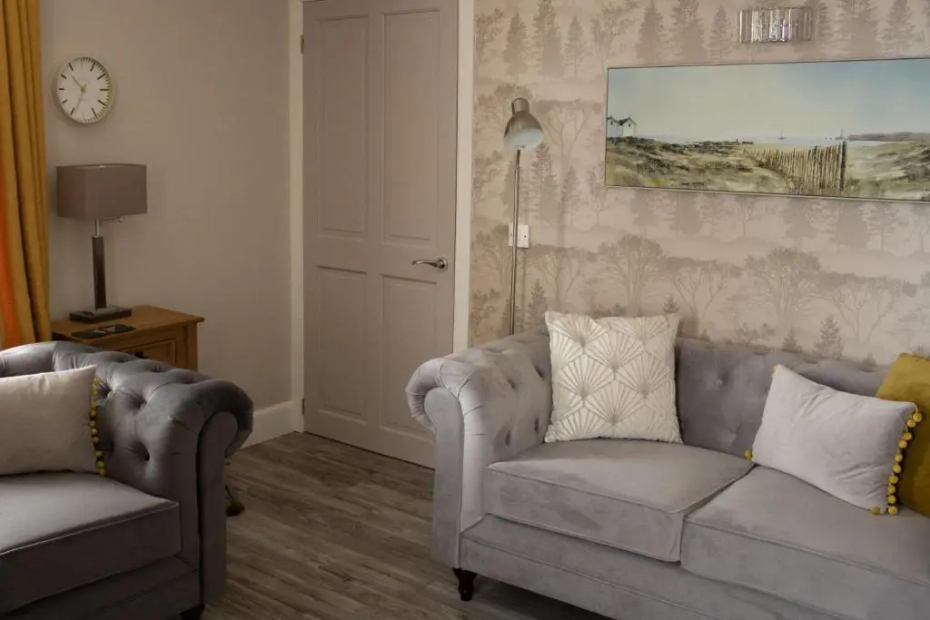 a living room with two chairs and a couch at Buttermere Cottage in Banff