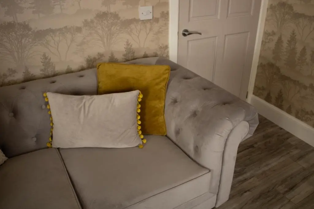 a couch with two pillows on it in a room at Buttermere Cottage in Banff