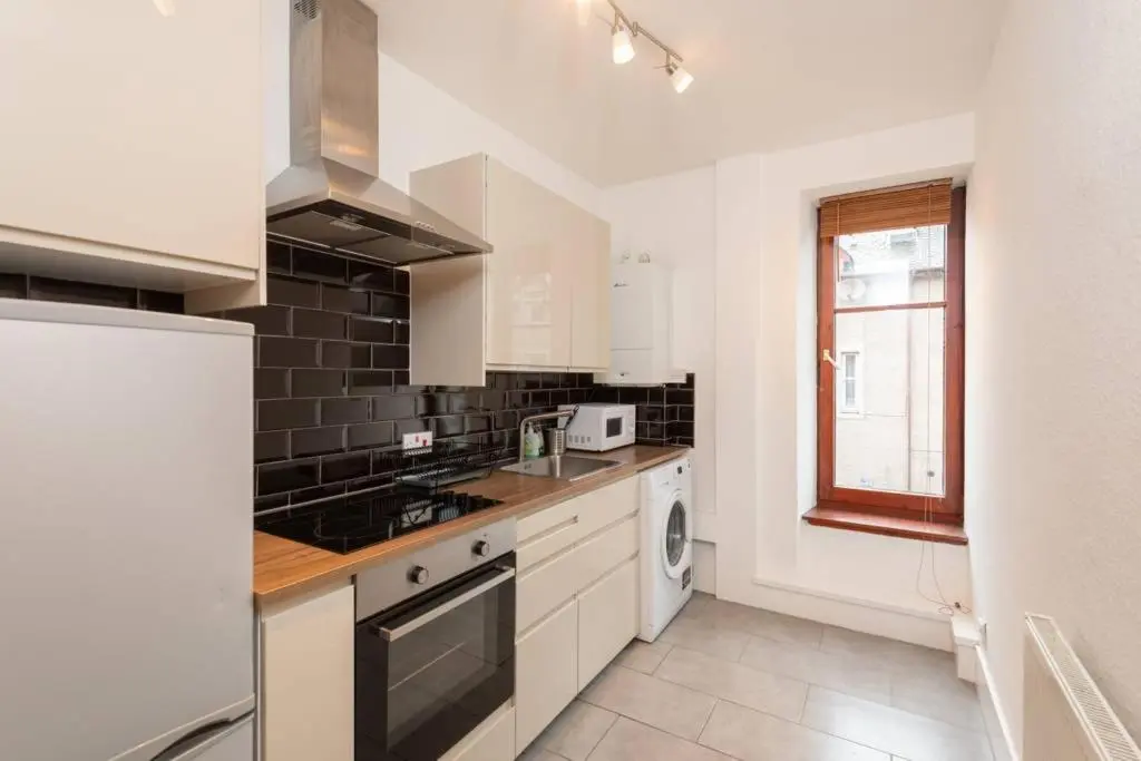 a kitchen with white appliances and a window at Ness Central Apartment - Greig Street in Inverness