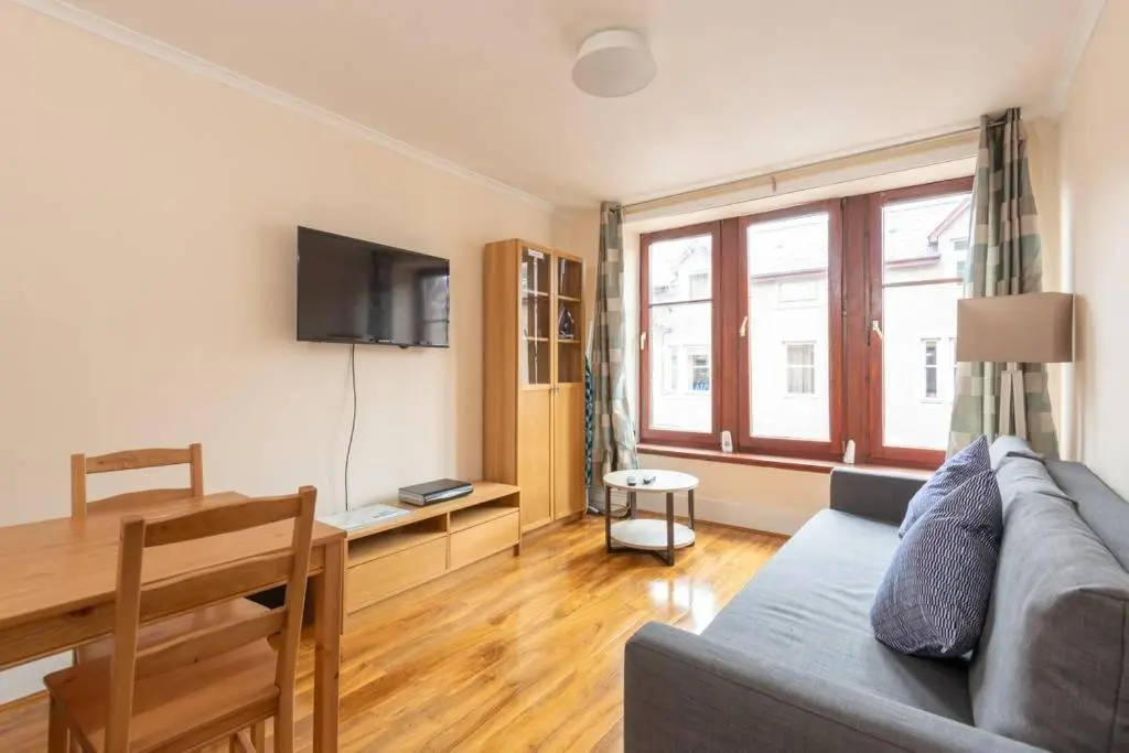 a living room with a couch and a table at Ness Central Apartment - Greig Street in Inverness
