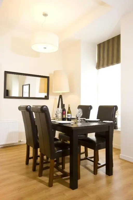 a dining room with a black table and chairs at Inverness City Suites in Inverness