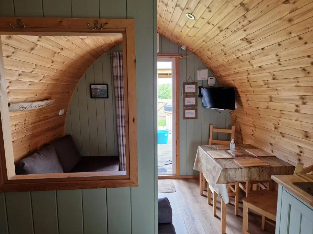 a room with a large window in a tiny house at Hillside Havens in Dufftown