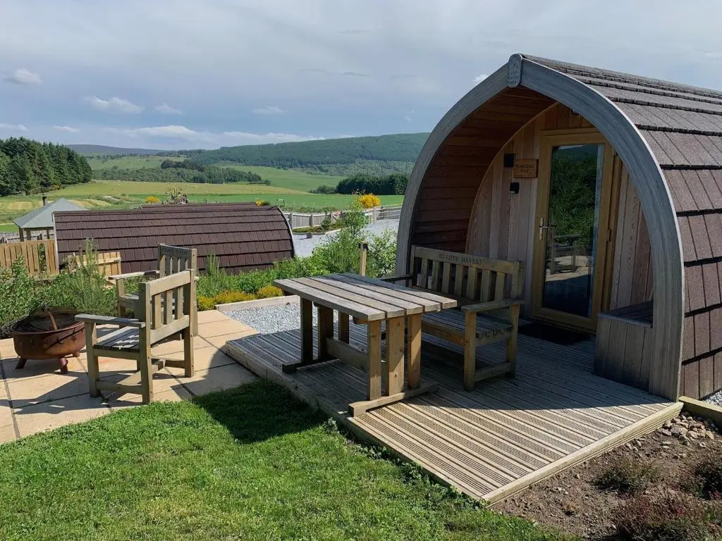 a gazebo with a wooden table and two benches at Hillside Havens in Dufftown