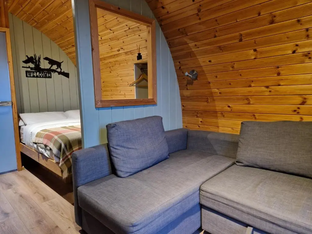 a room with a couch and a bed in a cabin at Hillside Havens in Dufftown